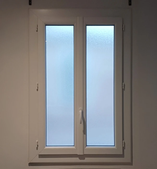 Intérieur résidentiel avec fenêtre à double battant ouvrant à la française, installée dans mur blanc