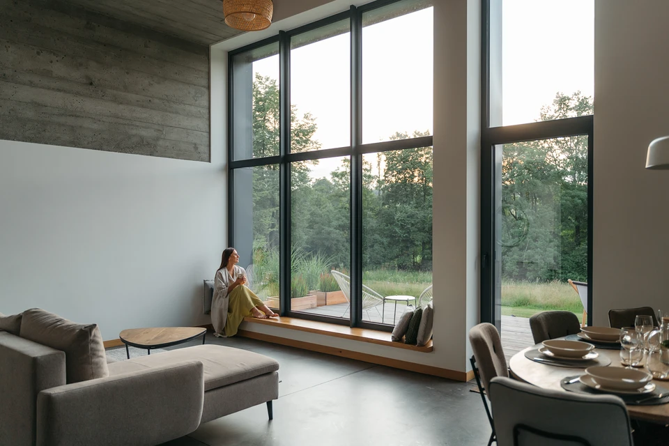 Atelier de menuiserie avec femme artisan travaillant sur &eacute;tabli, portant chemise &agrave; carreaux rouge, tablier gris, lunettes de protection et casque antibruit