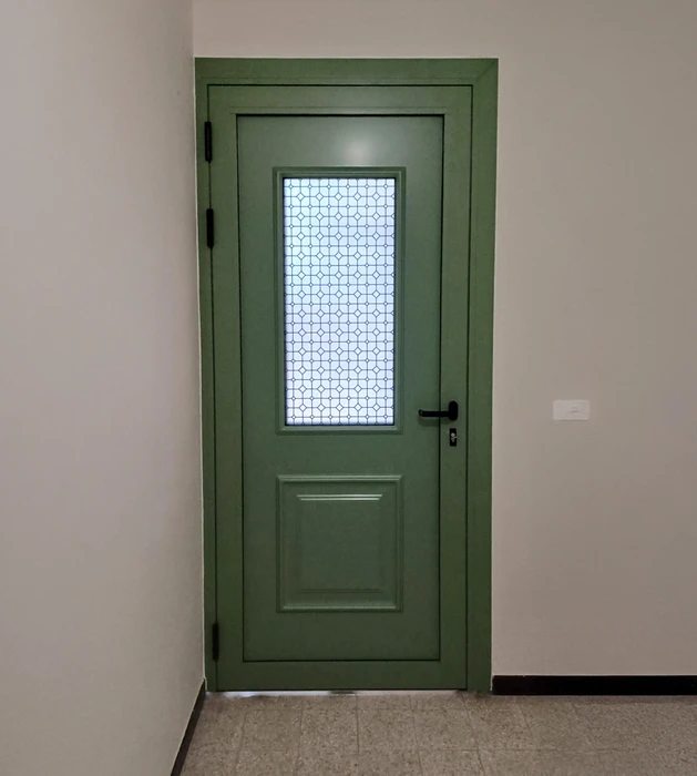 Terrasse moderne d'appartement avec baies vitrées coulissantes en aluminium, carrelage gris grand format, garde-corps blanc et jardinières noires contenant des arbustes