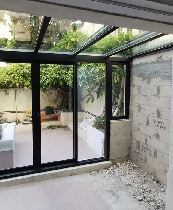 Véranda moderne avec structure métallique noire et verrière
