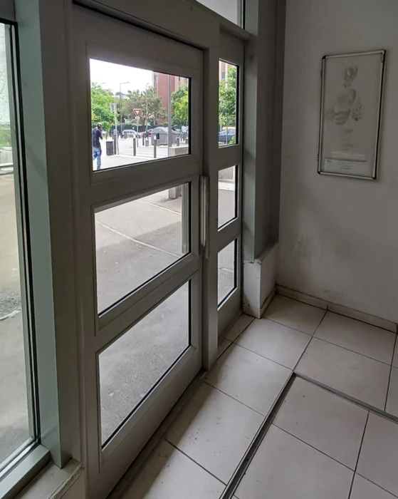 Intérieur moderne avec cloison verrière à montants métalliques noirs séparant deux espaces